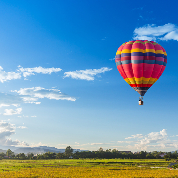 Colourful hot air balloon over a green field