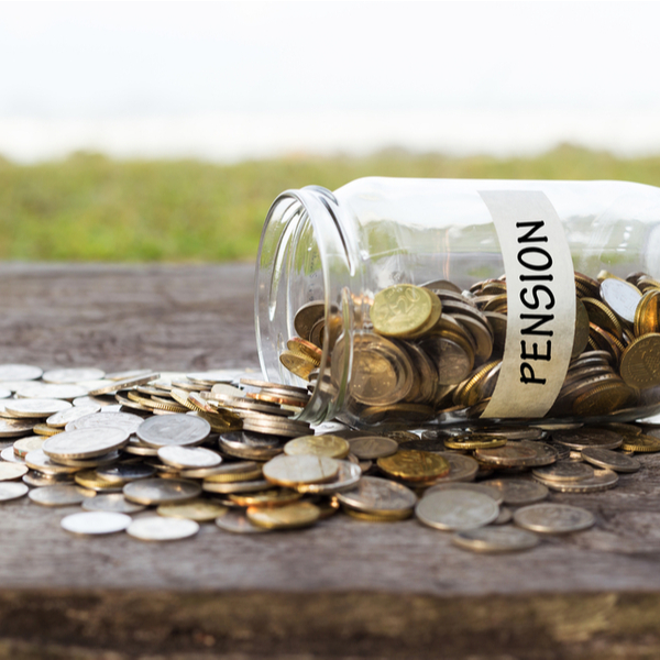 Jar labelled “pension” tipped over with coins spilling out