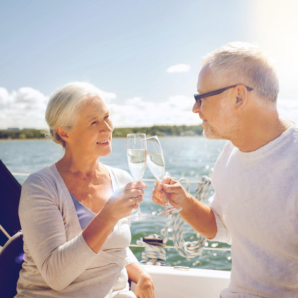 Senior couple clinking champagne on a yacht deck