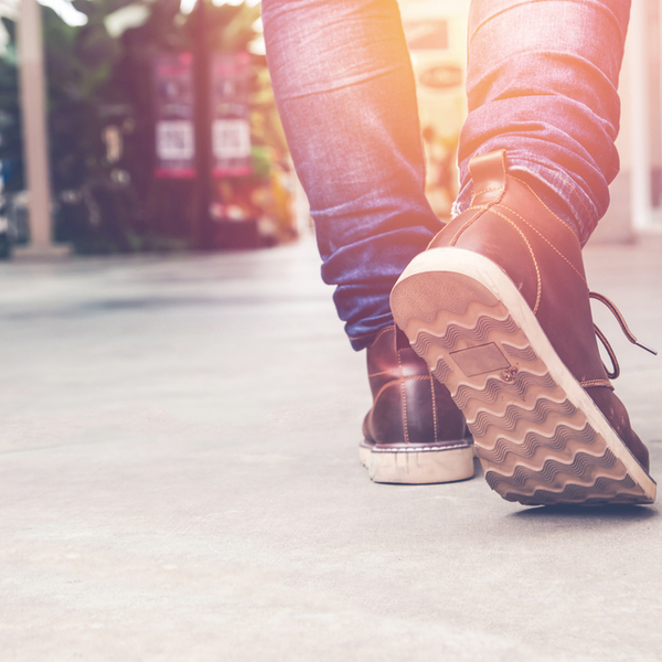 Close up of someone walking through a city in the sunlight