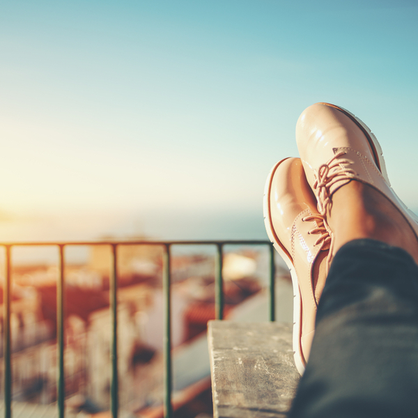 Close up of a woman sitting with their feet up on a balcony