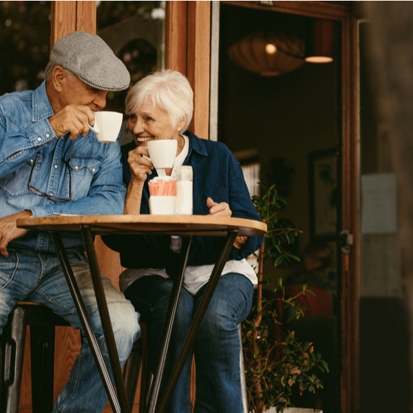 A senior couple enjoying a coffee outside of a cafe