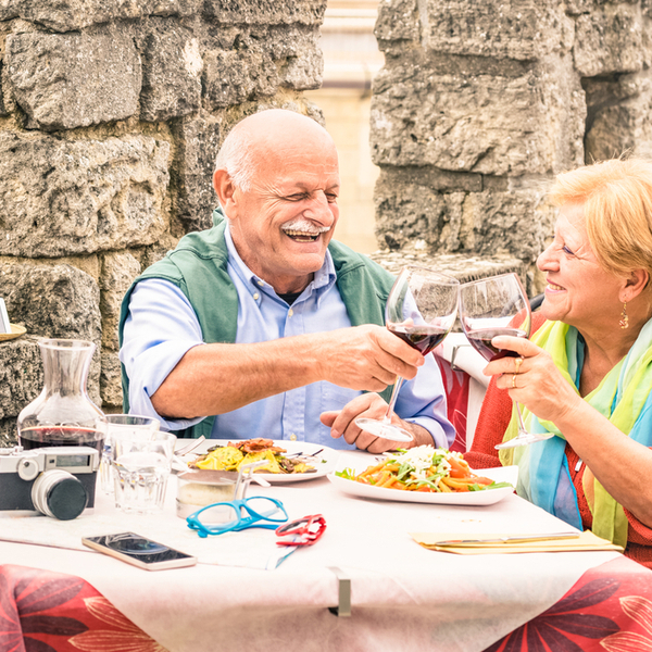 An older couple eating at a restaurant while on holiday.