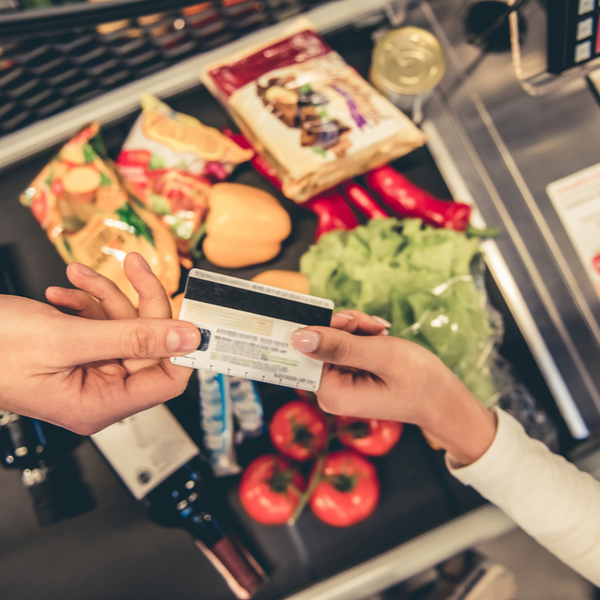 A customer handing over a bank card to pay for goods in a supermarket.
