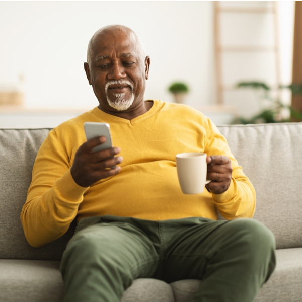 A man enjoying a cup of coffee and looking at his phone.