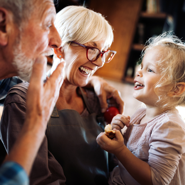 Grandparents playing with their granddaughter.