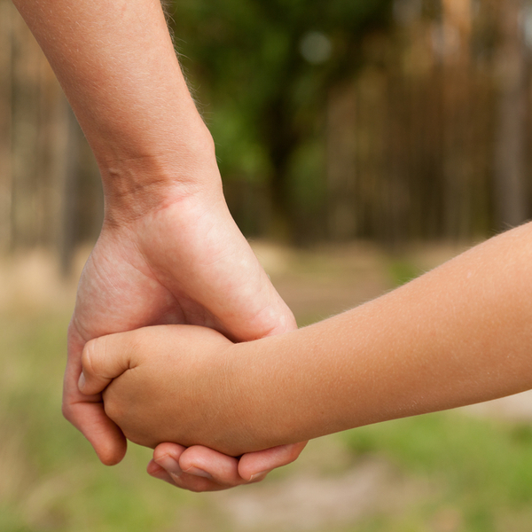 A parent and child holding hands.