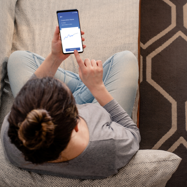 A woman looking at investments on her phone.