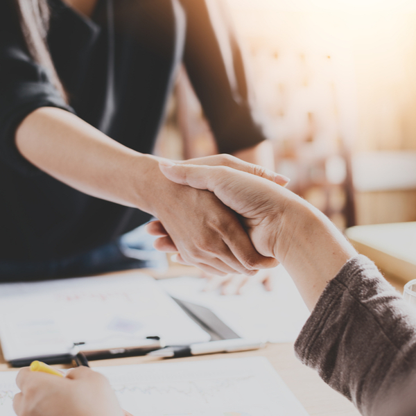 Two people shaking hands in an office.