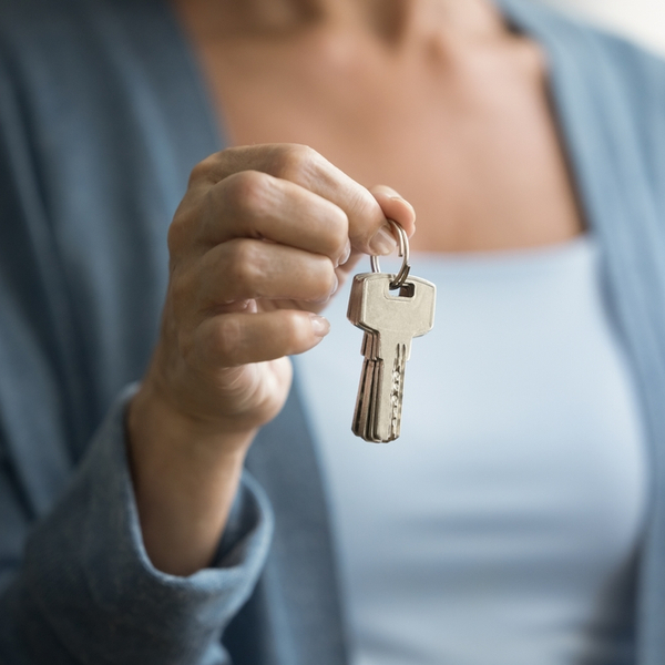 A woman holding up keys.