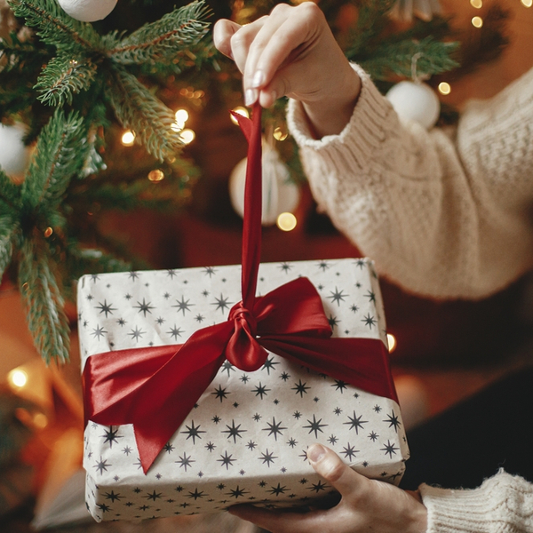 A woman unwrapping a Christmas gift.