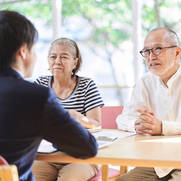 An older couple sits across a table from a younger man.