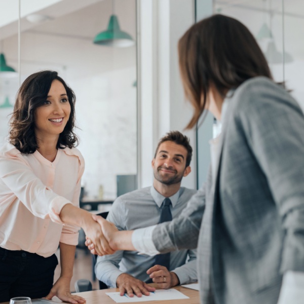 Two women shaking hands.