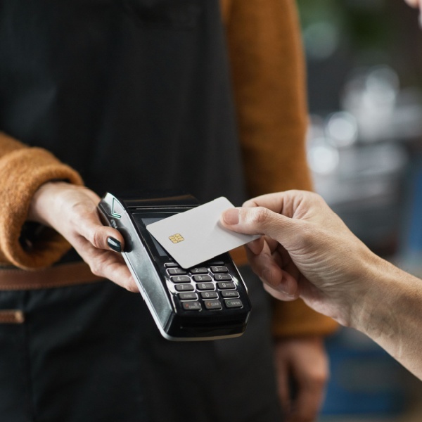 A person paying in a cafe using a contactless card.