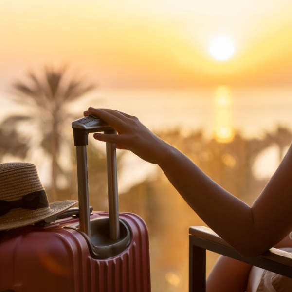 A woman sitting with a suitcase.