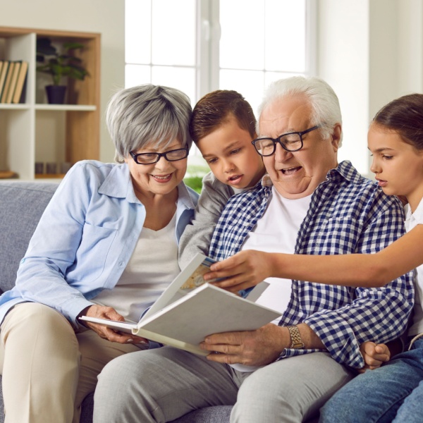 Grandparents looking at a photo album with their grandchildren.