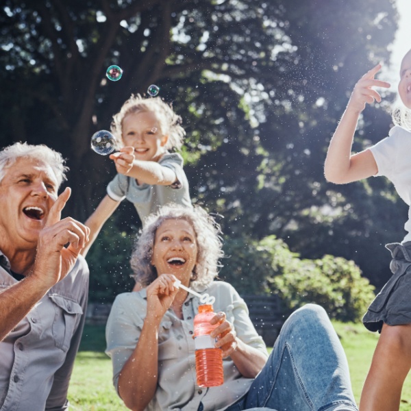 Grandparents blowing bubbles with their grandchildren.