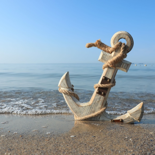 A wooden anchor on a beach.