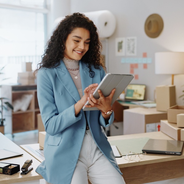 A female business owner using a tablet in an office.