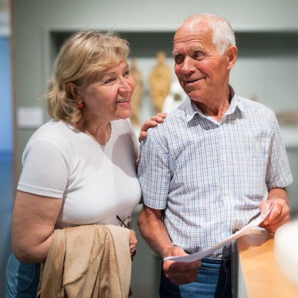 A couple looking at a statue in a museum.