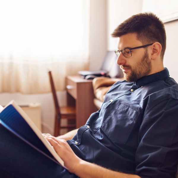 A man reading a book in his home.