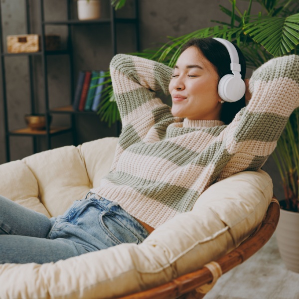 A woman relaxing with headphones on.