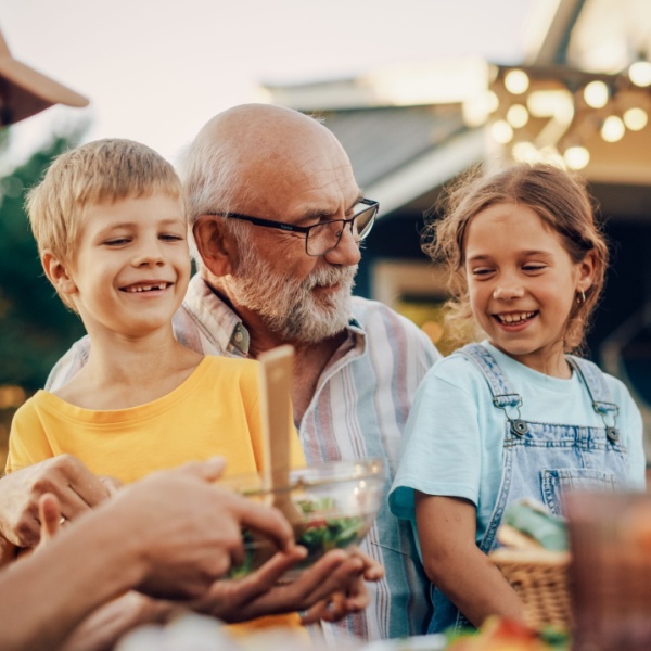 A grandfather laughing with his grandchildren.