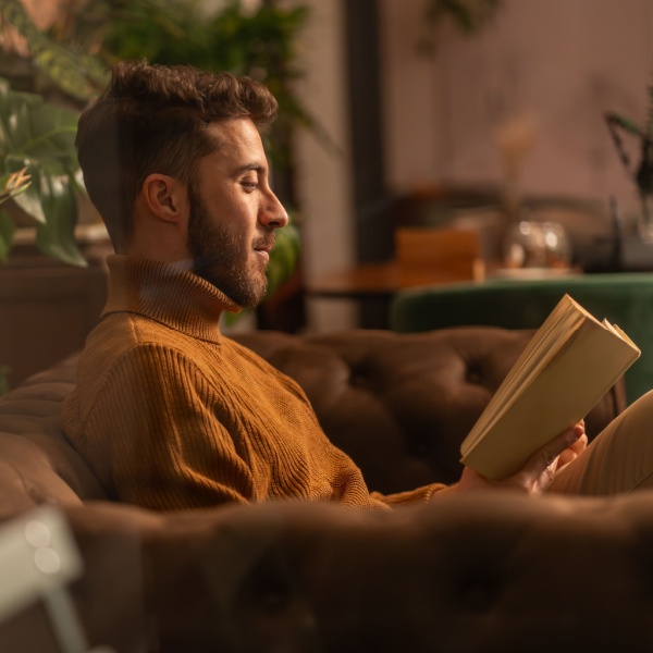 A man reading a book at home.