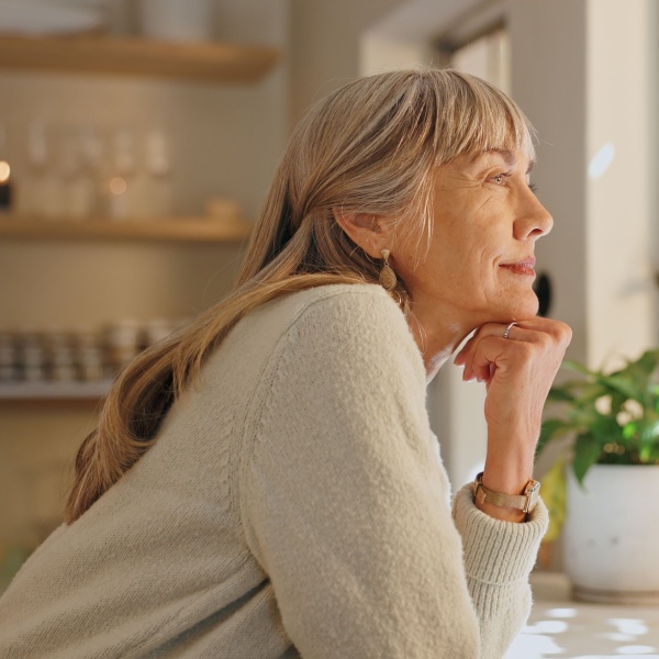 A woman looking out of the window at home.