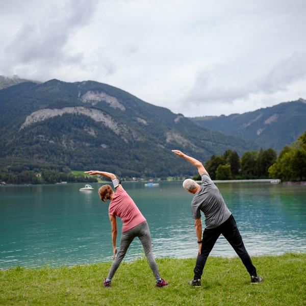 Couple doing tai chi by a lake