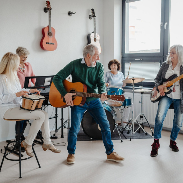 A group of people in their 50s playing musical instruments in a band.
