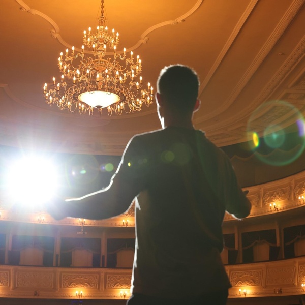 An actor rehearsing on a theatre stage.