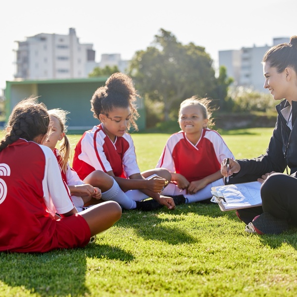 A woman coaching a girl’s football team.