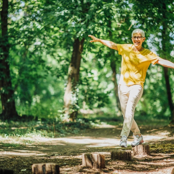A woman doing balancing exercises outdoors.