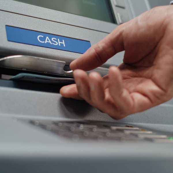 A person using an ATM to withdraw cash.