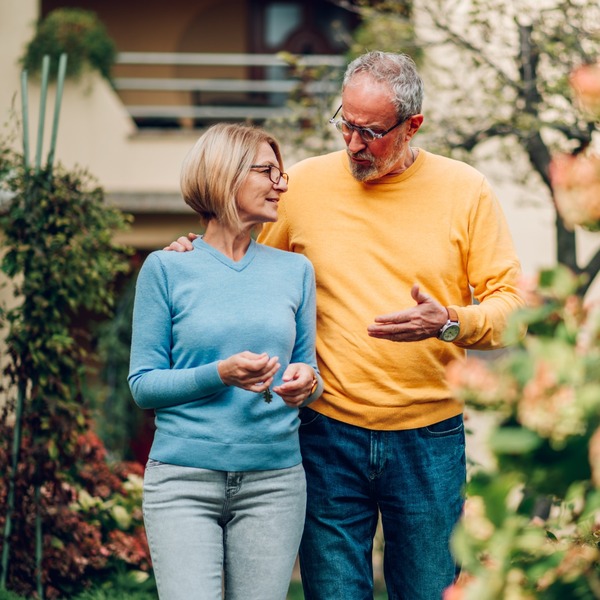 Mature couple walking outside a house