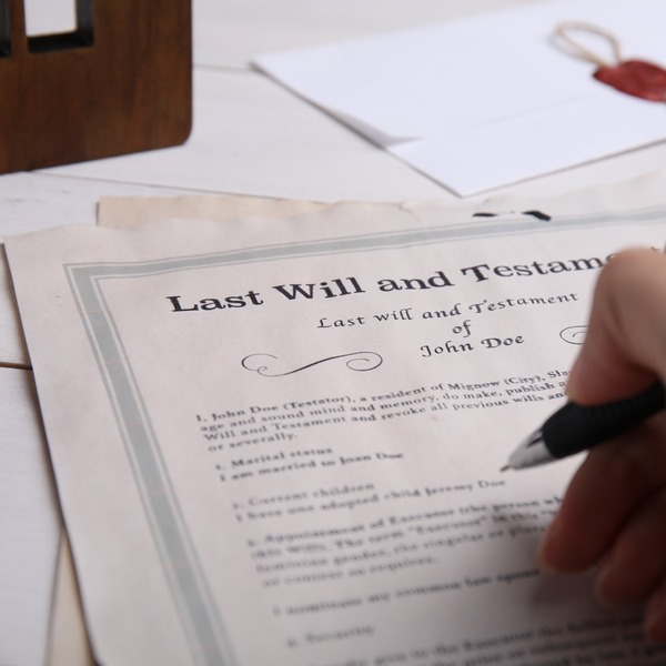 A person signing a will.