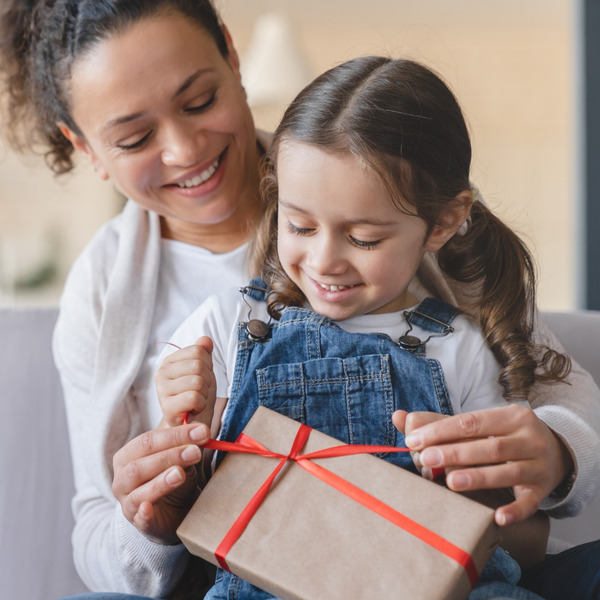 A mother and daughter unwrapping a gift.