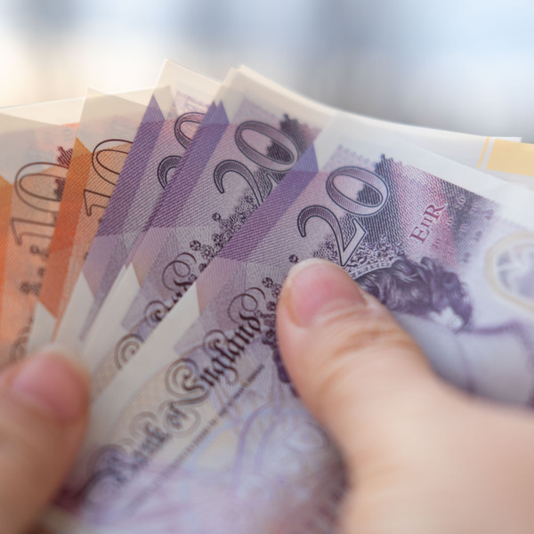 A person holding UK bank notes.