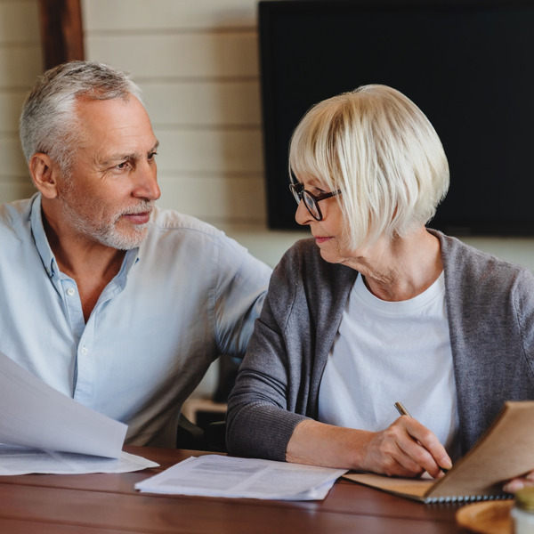 A mature couple talking and looking at paperwork together